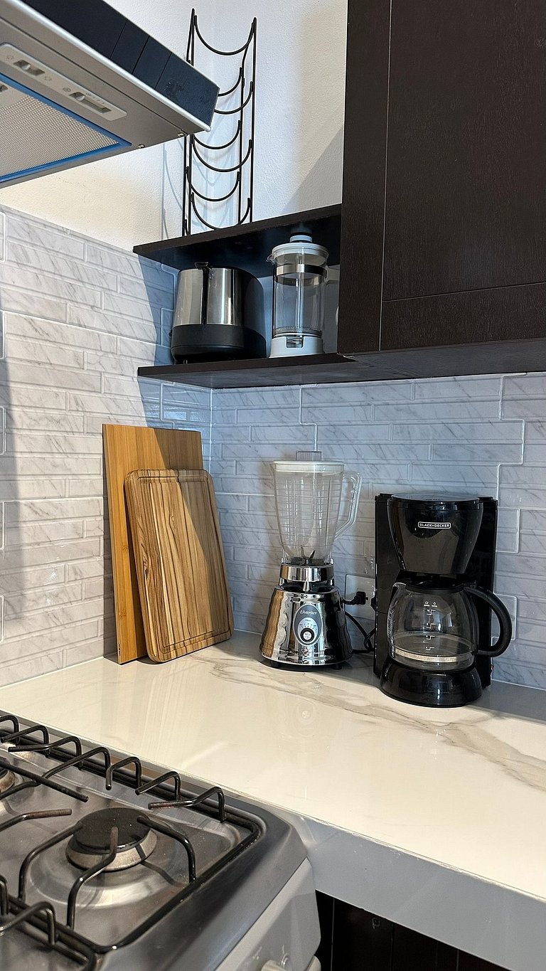 Acceso a alberca rodeada de palmeras, cerca de tiendas frent